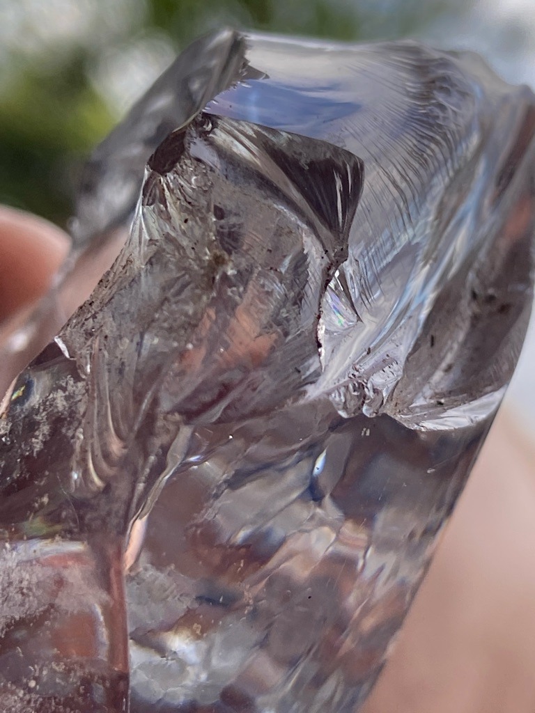 Not a diamond; this specimen exhibits clear conchoidal fracture patterns, curved striations, and lack of crystal cleavage characteristic of glass, quartz, or slag, not a crystalline diamond. - Raw, unpolished, amorphous crystal or slag fragment with no standard cut shape.