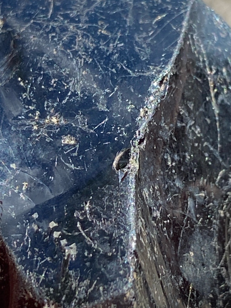 Not a diamond; appears to be a mineral specimen, possibly raw corundum, tourmaline, or a weathered dark stone matrix with inclusions. - Rough, uncut, irregular natural crystal form