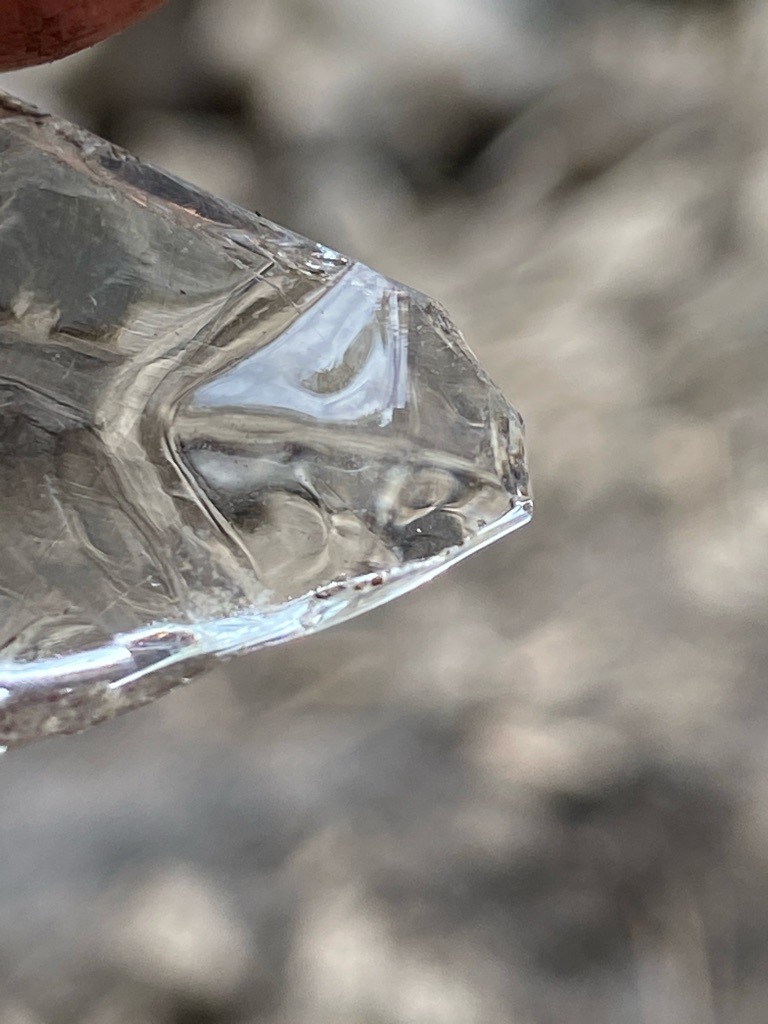 Not a diamond; appears to be raw quartz or glass crystal based on conchoidal fractures and lack of diamond crystal habit. - Raw, unpolished crystal fragment with irregular natural or fractured facets.