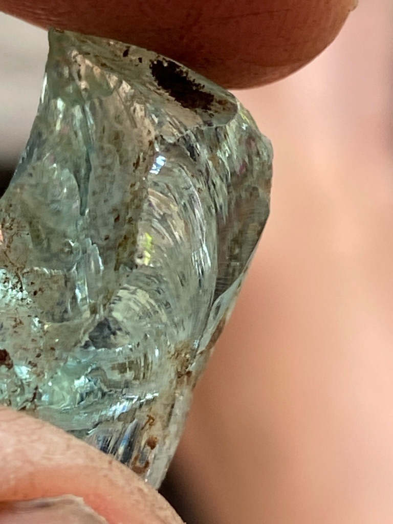 Not a diamond; this is a rough mineral crystal, likely a green-blue beryl (aquamarine) or tourmaline, displaying characteristic conchoidal fractures and striations. - Rough uncut crystal / Native crystal form