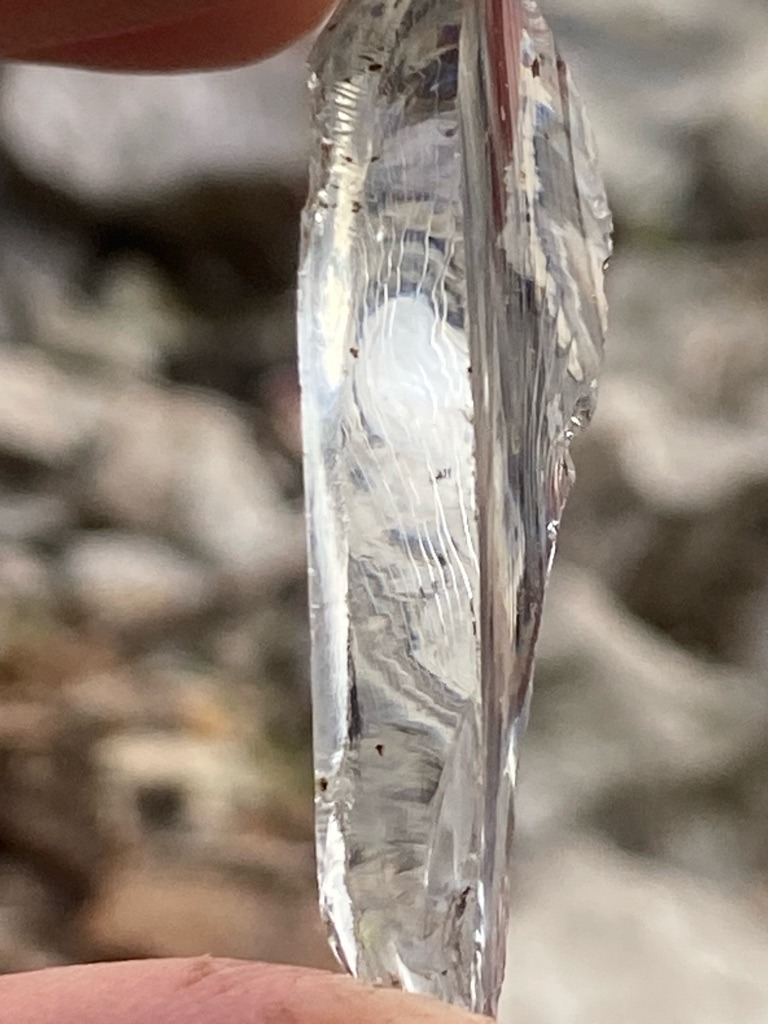Not a diamond; appears to be a natural quartz crystal fragment or mineral glass with distinctive conchoidal fracture patterns. - Irregular raw crystal fragment / elongated shard