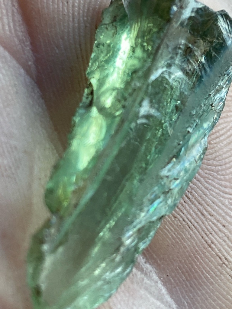 Not a diamond; appears to be raw green glass or slag material - Rough, unworked fragment with irregular elongated morphology