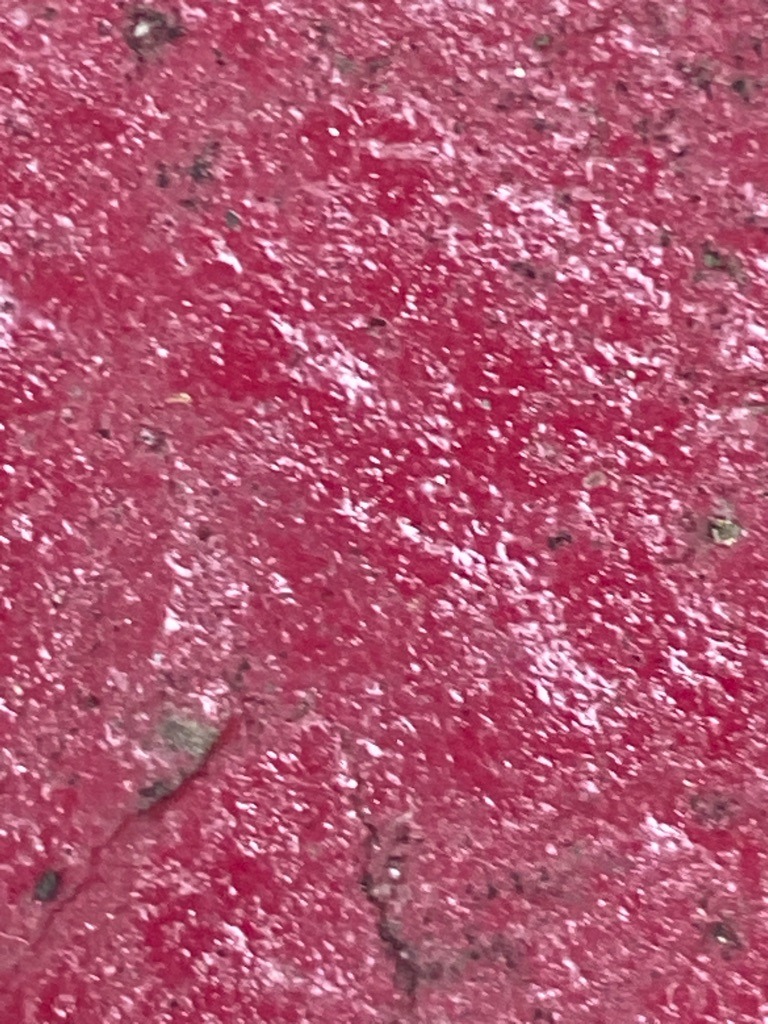 Not a diamond; appears to be a textured red surface, possibly painted concrete, asphalt, or a coated material. - N/A