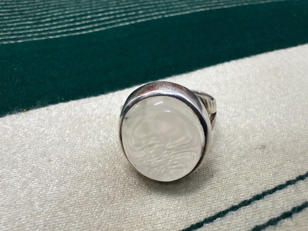 The central gem appears to be a natural gemstone or cabochon-cut quartz/agate rather than a standard faceted diamond, set in a bezel mount. - Cabochon (Oval/Round)