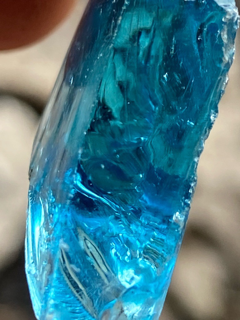 Not a diamond; this specimen appears to be blue glass or synthetic slag, displaying conchoidal fracture patterns and vitreous luster typical of amorphous materials rather than crystalline diamond. - Rough uncut piece with conchoidal fracture surfaces