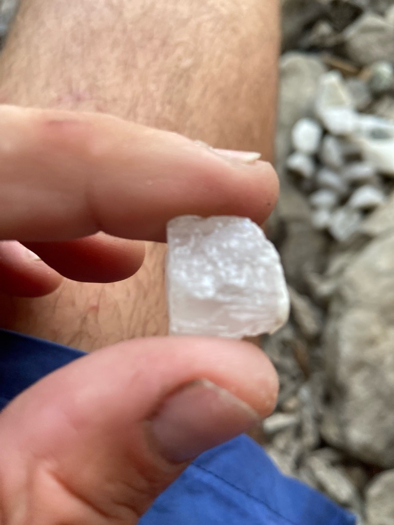 Not a diamond; likely raw quartz or calcite crystal based on rough crystal habit and vitreous luster found in a field/river setting. - Rough crystal / Irregular uncut form