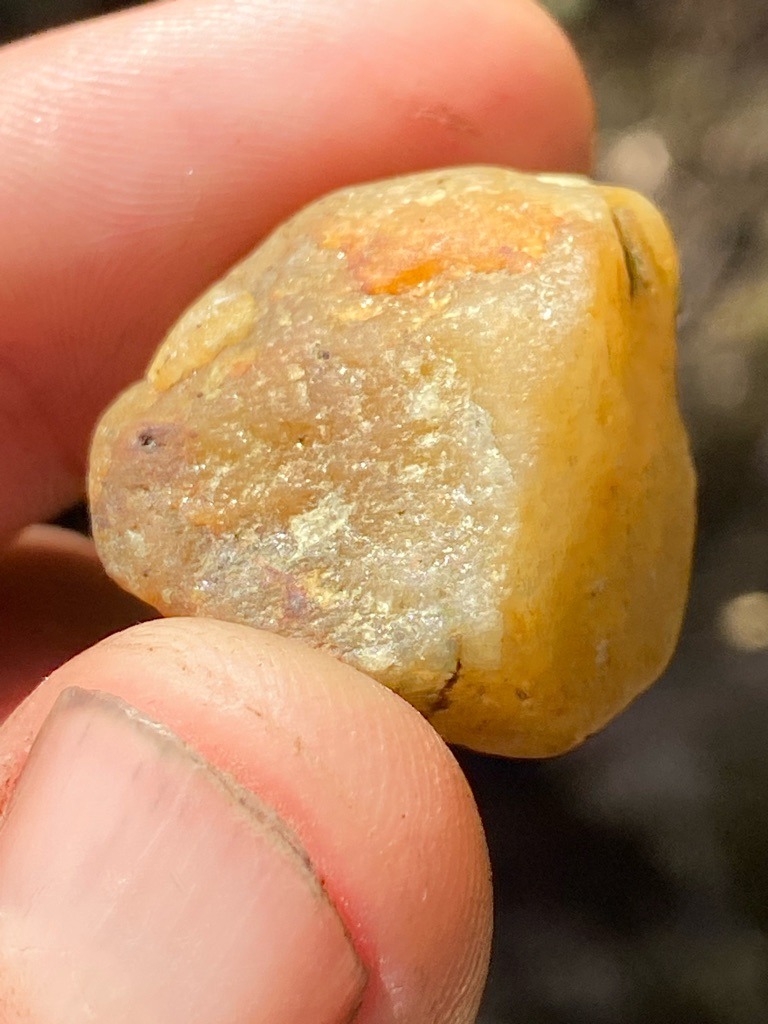 The specimen shown is an uncut, raw alluvial stone, likely Quartz, Jasper, or potentially a rough industrial-grade diamond crystal coated with mineral oxides, but visually resembles raw quartz or quartzite rather than gem-quality diamond. - Rough/Uncut natural pebble form with rounded, weathered contours.