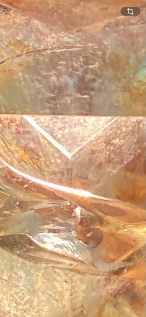 Unable to verify definitively from macro image; likely quartz, agate, or synthetic simulant rather than a standard faceted diamond due to fibrous internal structures and unusual coloration - Irregular macro view showing crystalline facets and fracture planes