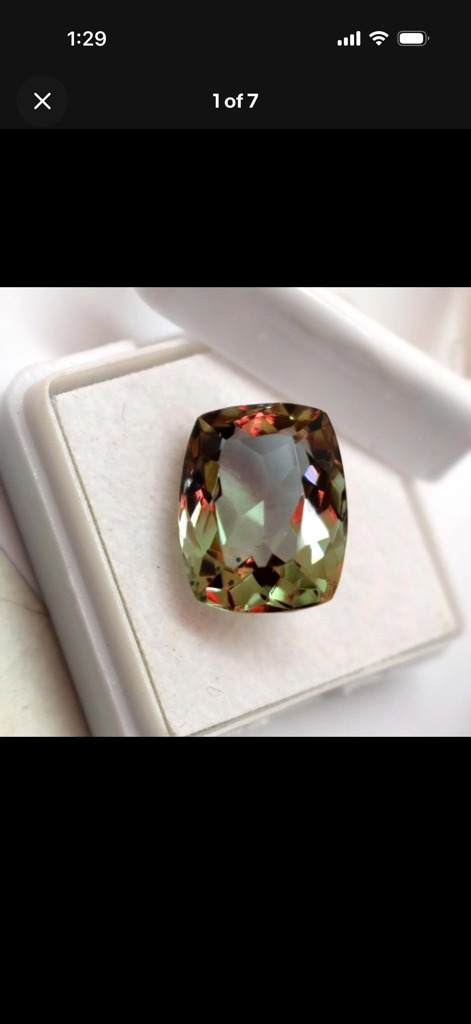 Not a diamond; this gemstone appears to be an alexandrite or a color-change synthetic corundum/sapphire due to the distinct greenish-brown body color shifting to reddish hues at the edges and facets. - Cushion Modified Brilliant