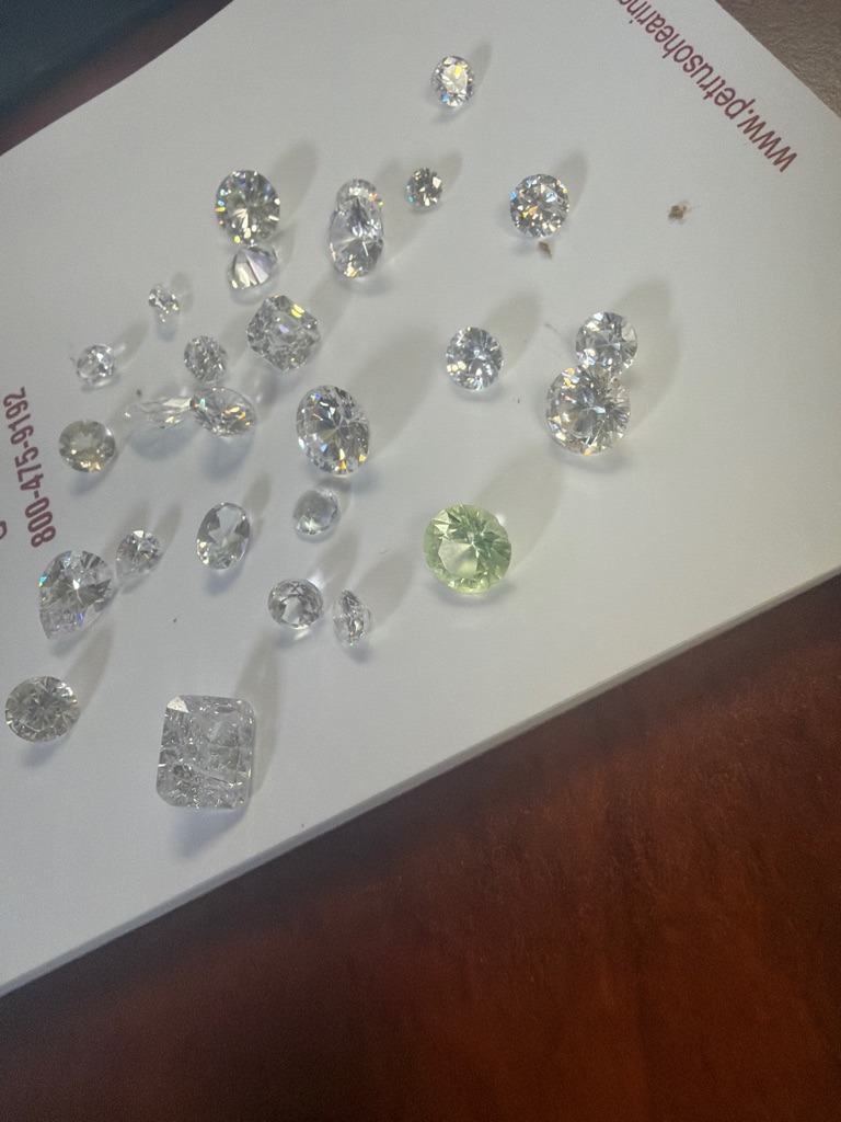 Mixed parcel containing primarily Natural Diamonds, with potentially some Lab-Grown or colored gem accents (specifically noting a prominent yellow/green stone). - Assortment including Round Brilliant, Radiant, Oval, Pear, Cushion, and Marquis cuts.
