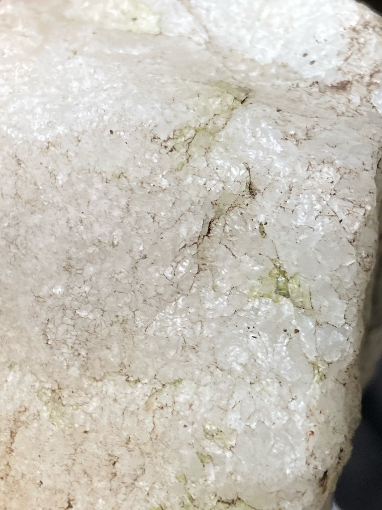 The image shows a raw mineral matrix, possibly quartzite or marble with mineral staining, rather than a cut diamond. - Rough or unshaped matrix, non-geometric.