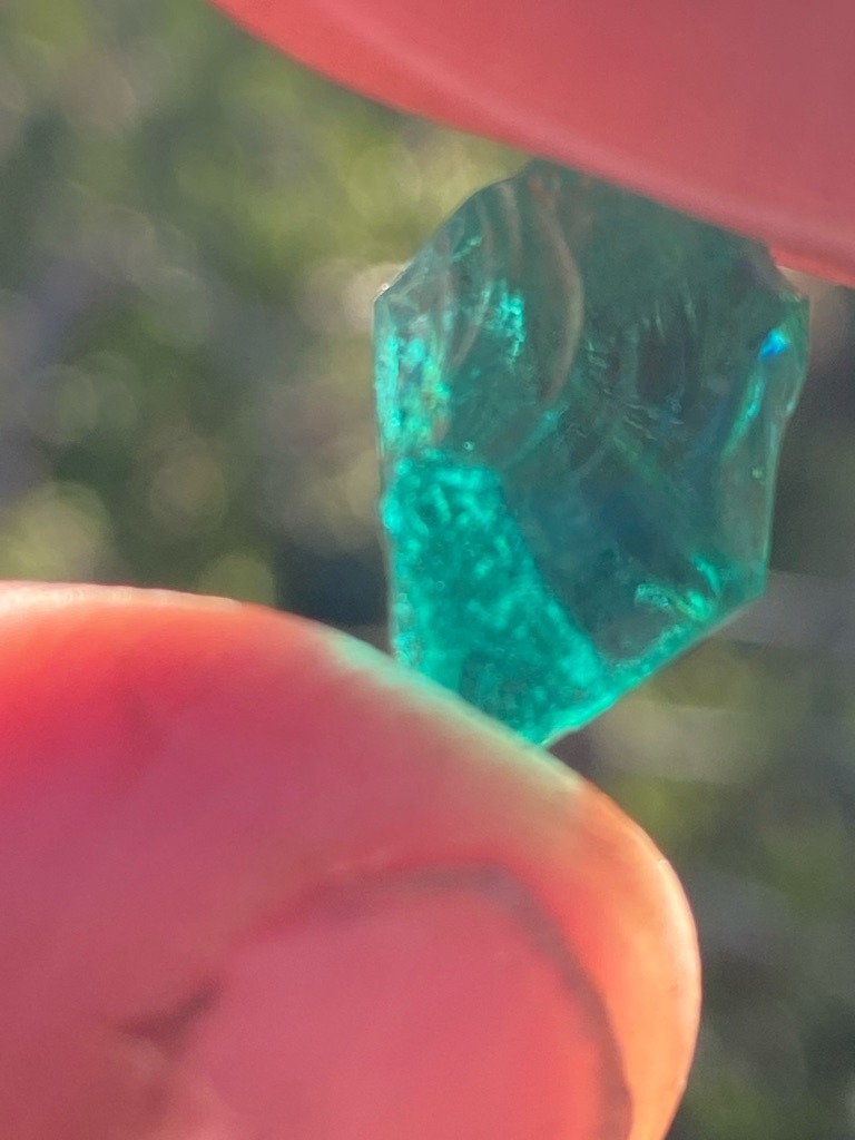 Not a diamond; appears to be colored glass or slag glass, or potentially a low-value green mineral/gemstone raw specimen. - Rough, unpolished, irregular raw crystal form with melted or tumbled edges.