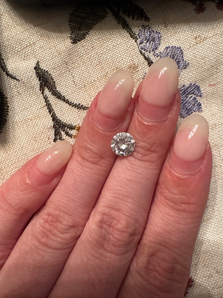 Natural or Lab-Grown Diamond (Visual assessment indicates a high probability of a modern round brilliant diamond or quality simulant, requiring physical testing for definitive determination) - Round Brilliant