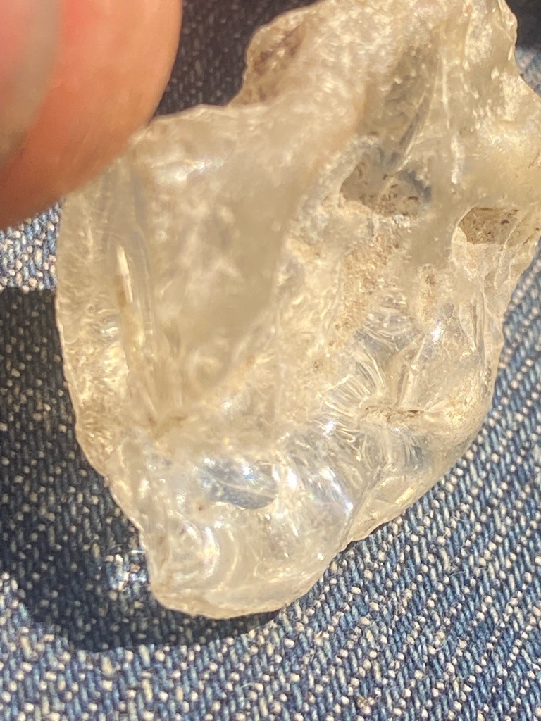 The specimen does not appear to be a diamond; the visual characteristics, specifically the conchoidal (shell-like) fracture patterns and waxy luster, are indicative of common Quartz or industrial Glass/Slag. - Rough/Uncut. The specimen lacks any defined crystal habit (like the octahedral shape typical of rough diamonds) and shows irregular, broken surfaces.