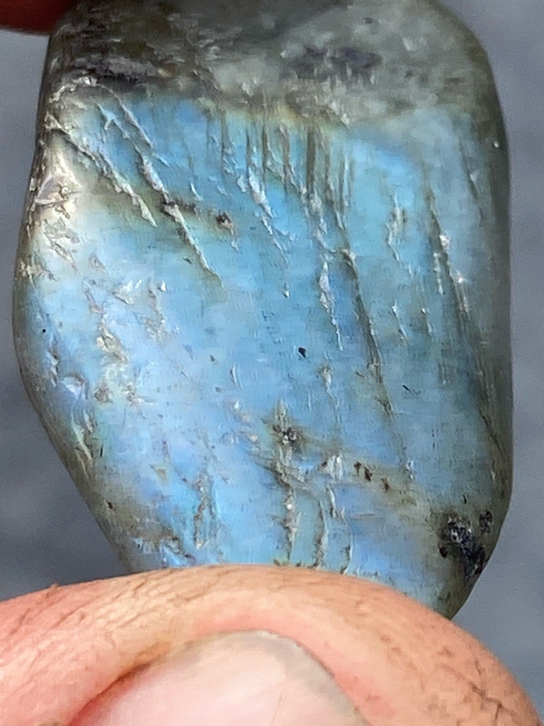 Not a diamond; this specimen is a natural mineral, specifically a piece of labradorite feldspar exhibiting labradorescence. - Rough or tumbled cabochon-like irregular pebble shape