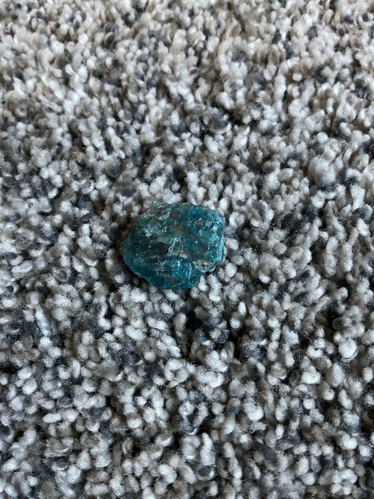 Unknown Mineral (Non-Diamond Evidence: The material possesses a translucent teal-to-blue coloration and a conchoidal fracture pattern that is inconsistent with a natural or synthetic diamond crystal). - Rough/Uncut (Amorphous, irregular mineral specimen).