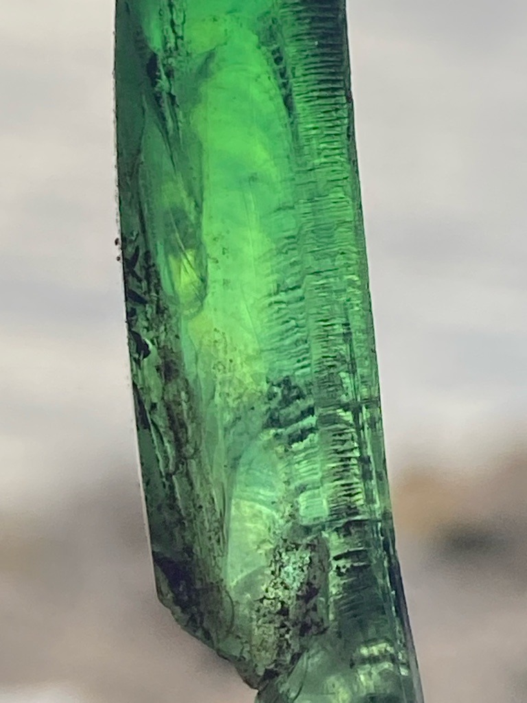 Not a diamond; this is a green mineral crystal, likely Tourmaline (Verdelite) or Emerald, characterized by distinct vertical striations typical of prismatic crystal growth. - Rough prismatic crystal form with natural striations and termination fragment, unpolished.