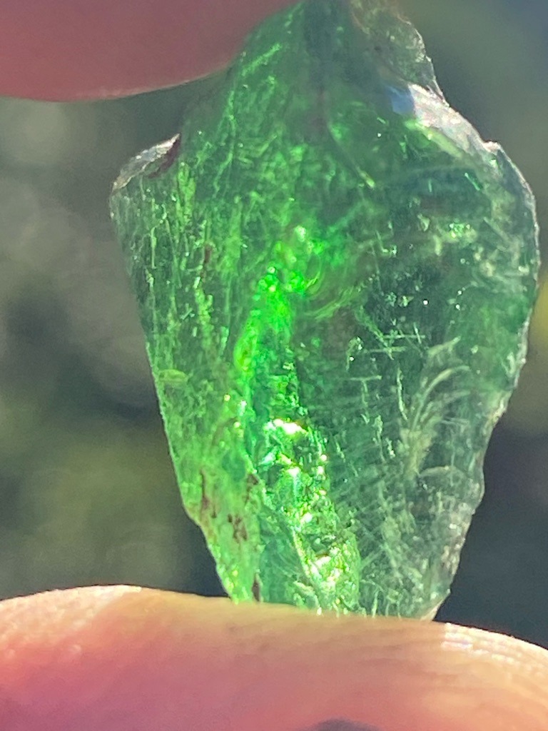 Not a diamond; this specimen appears to be green glass or slag, possibly colored with chromium or copper, exhibiting conchoidal fracture patterns. - Raw, unpolished, irregular fragment with natural or broken conchoidal surfaces