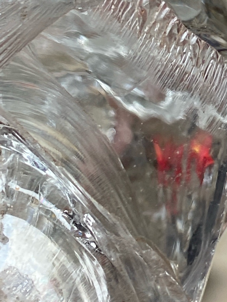 The provided image does not show a cut and polished diamond. Instead, it displays a distorted or irregular crystalline/glassy material with prominent parallel striations and surface grooves, resembling molded glass, synthetic quartz, or resin rather than a genuine diamond. - Irregular / Not Applicable
