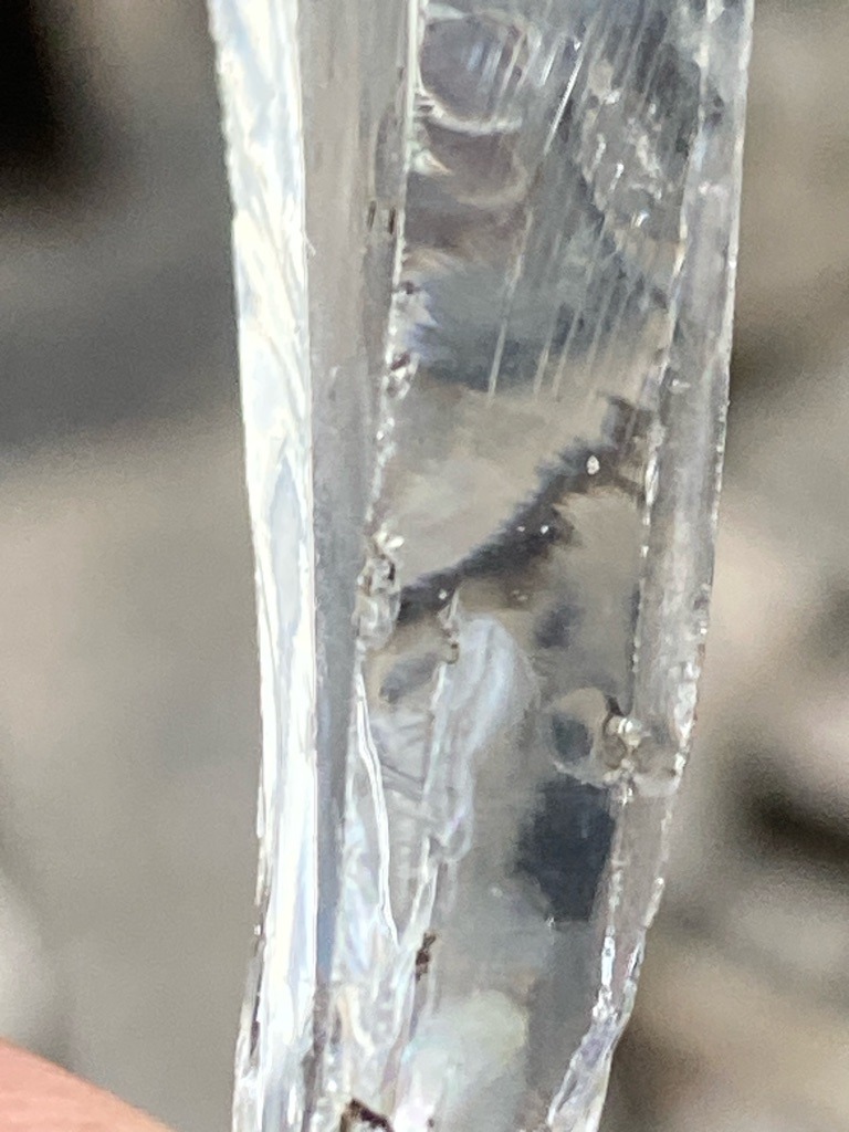 Not a diamond; this appears to be a natural icicle or transparent crystal formation containing trapped air bubbles and impurities. - Irregular columnar / natural elongated growth form