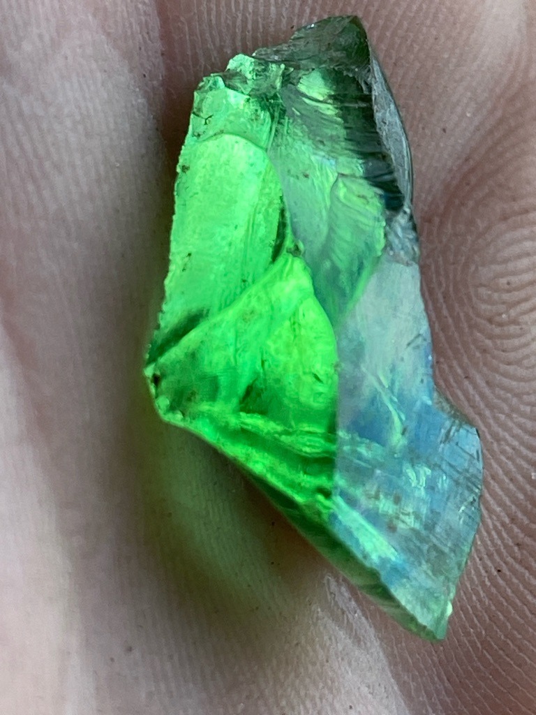 Not a diamond; this specimen appears to be green glass or synthetic slag, displaying conchoidal fracture patterns characteristic of amorphous materials. - Rough uncut fragment / irregular shard