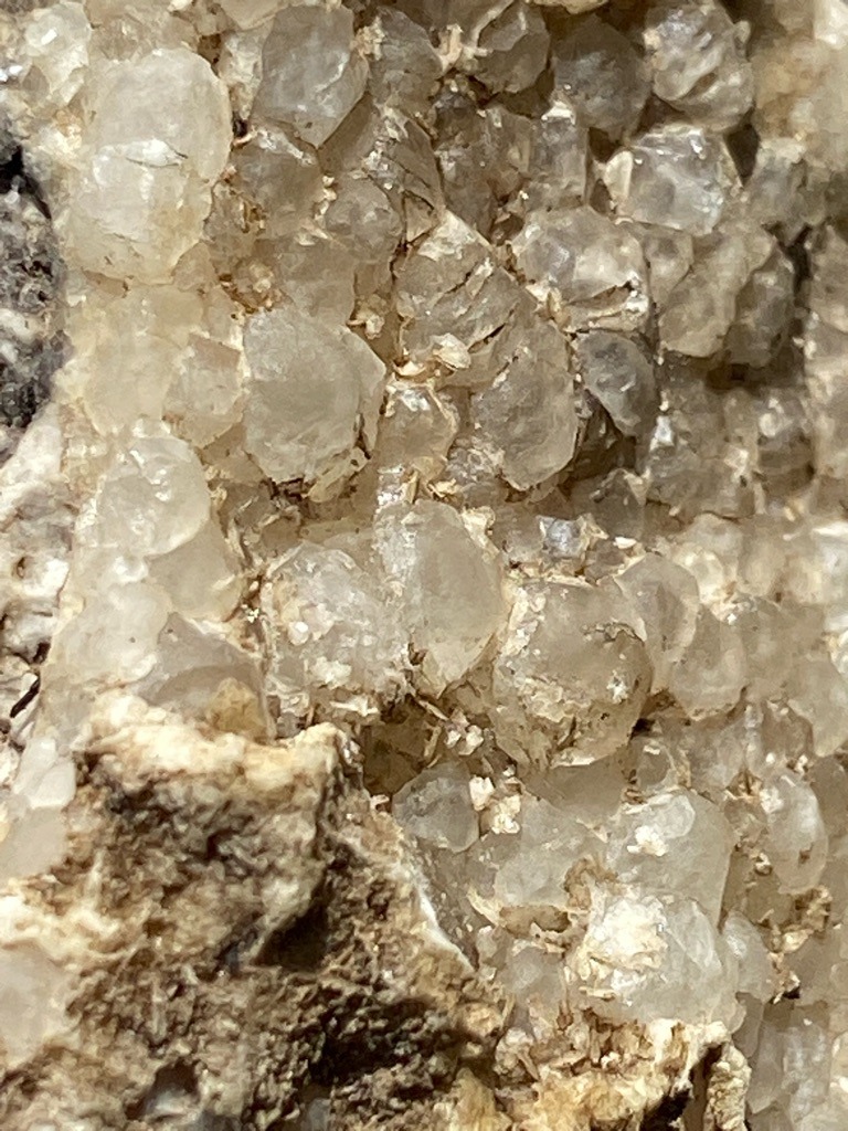 Not a diamond; this image displays rough mineral crystal clusters, likely quartz or calcite forming in a matrix rock formation. - Rough crystal clusters, unpolished and uncut aggregate formations.