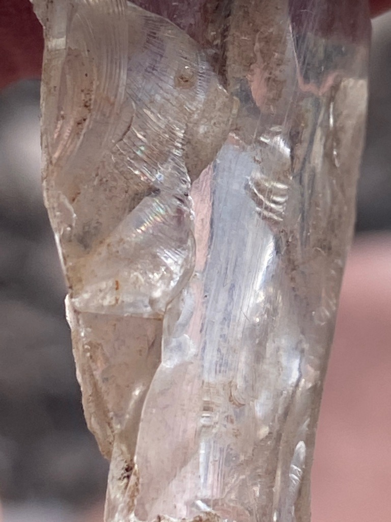 Not a diamond; appears to be raw quartz or another silicate mineral with conchoidal fracture and striations - Rough crystal / Irregular uncut fragment