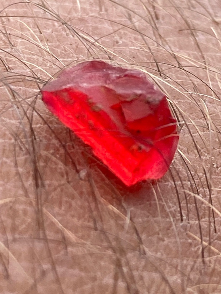 Not a diamond; visual characteristics strongly suggest a rough ruby or red spinel, likely a corundum or spinel crystal, or potentially a red glass/synthetic simulant. Pure red natural diamonds are extremely rare and typically show octahedral crystal forms rather than this irregular rough crystal morphology. - Rough crystal / Natural uncut form (Irregular nugget-like habit)