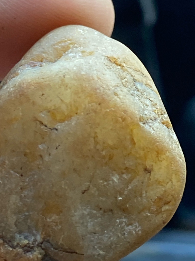 Not a diamond (appears to be a water-worn quartz or quartzite pebble, potentially with iron oxide staining) - Irregular, natural pebble shape (uncut/rough stone)