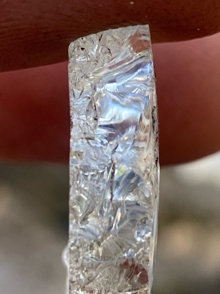 Not a diamond; appears to be quartz, glass, or a synthetic imitation material showing conchoidal fracture patterns. - Irregular / Raw fragment or cut piece with heavily fractured internal structure