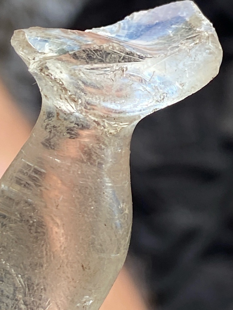 Not a diamond; this is heavily worn or fractured glass, possibly a melted bottle neck or slag glass. - Irregular, melted, and unshaped fragment