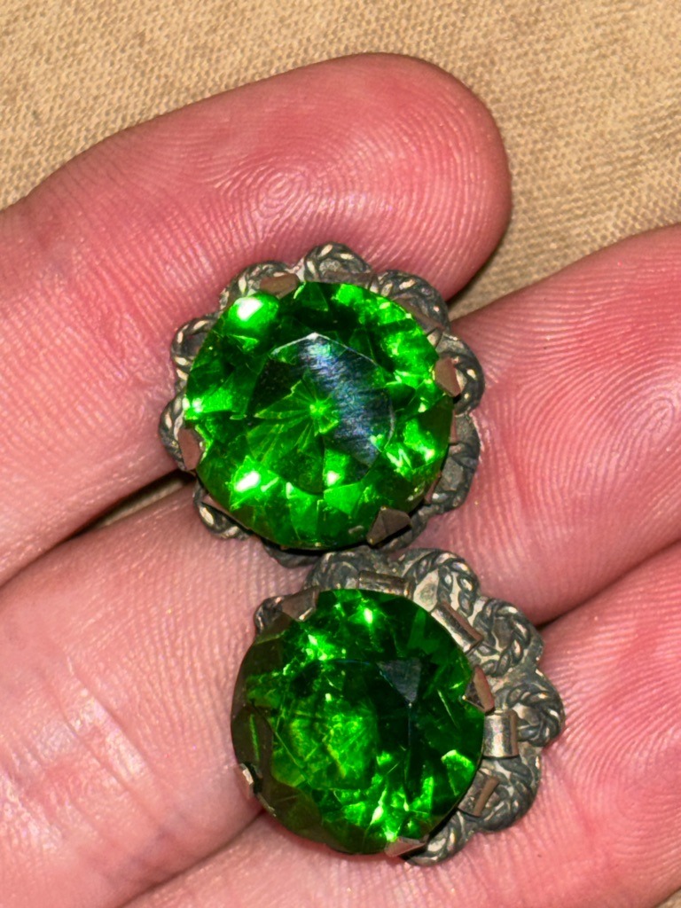 Not a diamond; these are vibrant green glass or synthetic crystal costume jewelry earrings (often referred to as paste or rhinestones). - Round with old mine or modified circular faceted cut.
