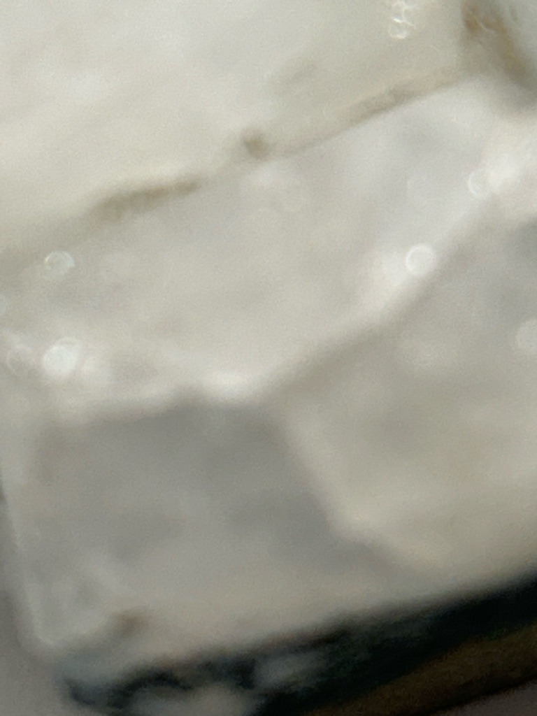 The provided image is out of focus and lacks clarity, making it impossible to perform a reliable gemological analysis or determine if the specimen is a natural diamond, lab-grown diamond, or another material. - Undetermined due to image blur and lack of clear facet structure.