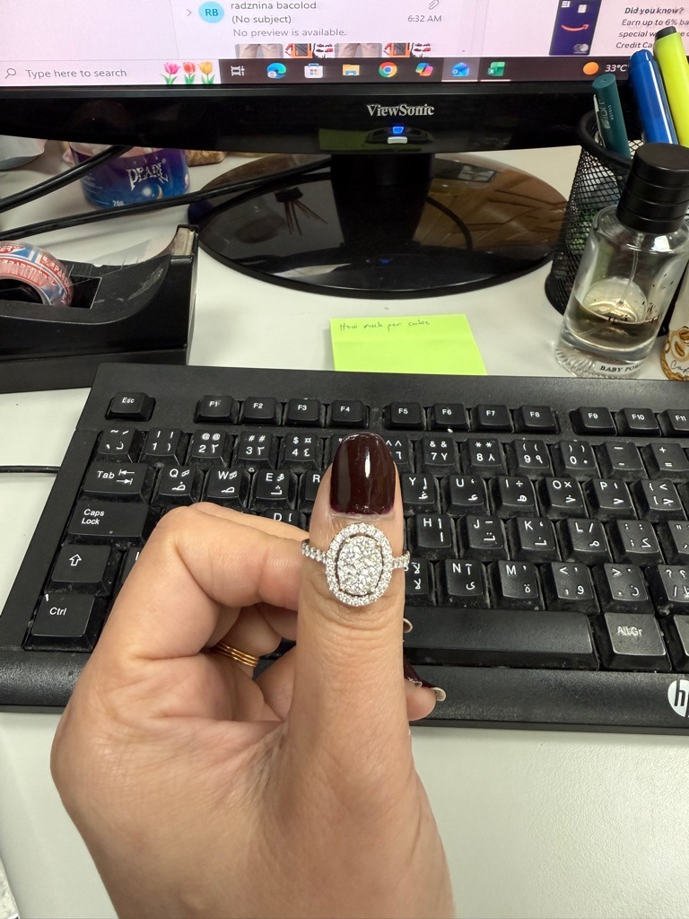 The ring features a cluster/composite of multiple small Round Brilliant natural diamonds rather than a single center stone. - The overall head of the ring is Oval in shape, composed of a pave-set center cluster and a surrounding halo.