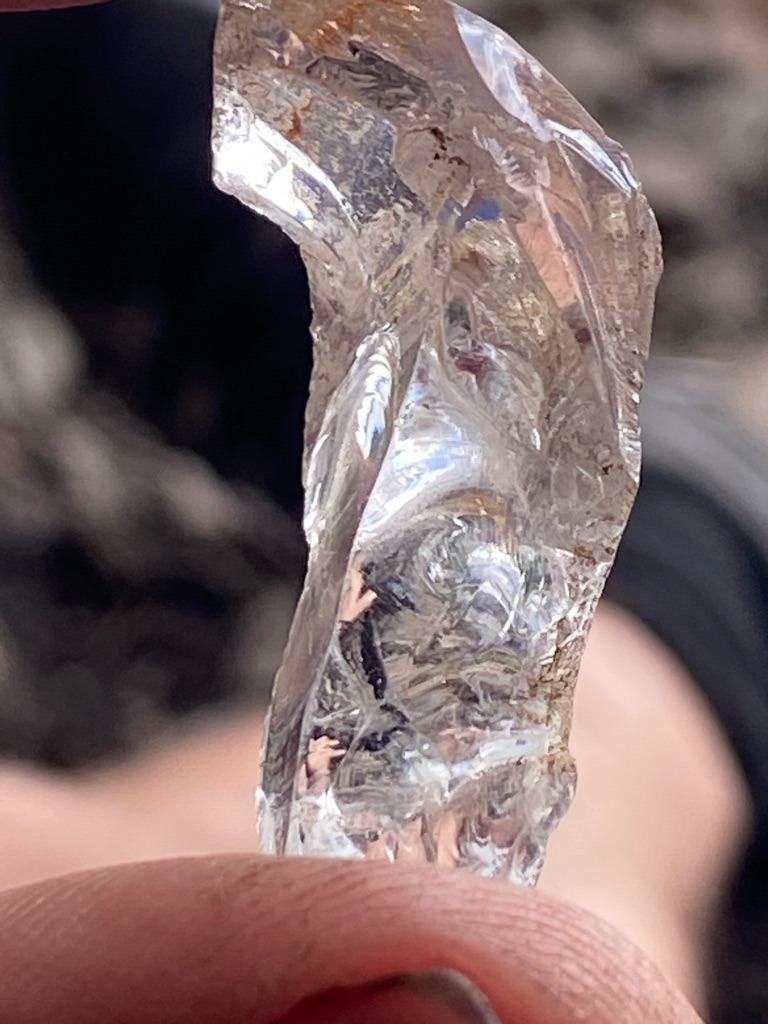 The specimen shown in the image appears to be rough, untreated mineral crystal, likely quartz or glass rather than a gem-quality diamond, exhibiting conchoidal fracture patterns characteristic of glass or quartz. - Irregular rough crystal fragment / Raw unstructured piece with no standard gem cut.
