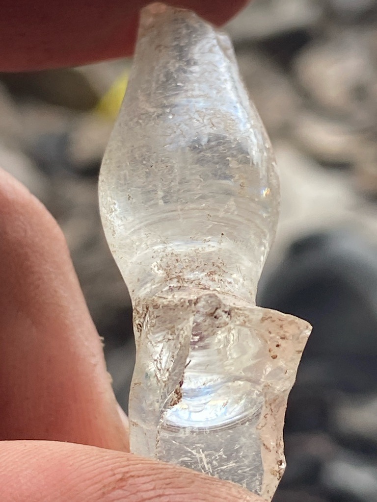 Not a diamond; this is a fragment of melted glass or a discarded glass artifact. - Irregular, bulbous, broken molten glass shape