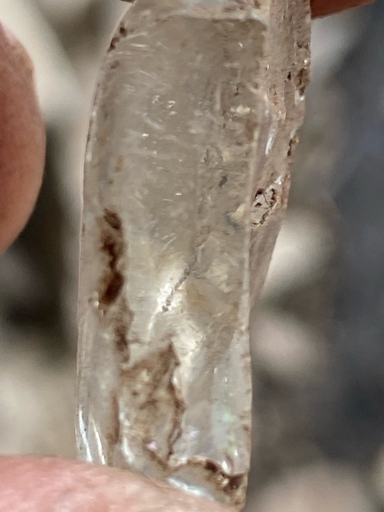 Natural rough crystal (likely quartz or similar mineral rather than a gem-grade diamond, given the surface etching, habit, and iron-oxide staining) - Uncut natural crystal / Irregular elongated rough fragment