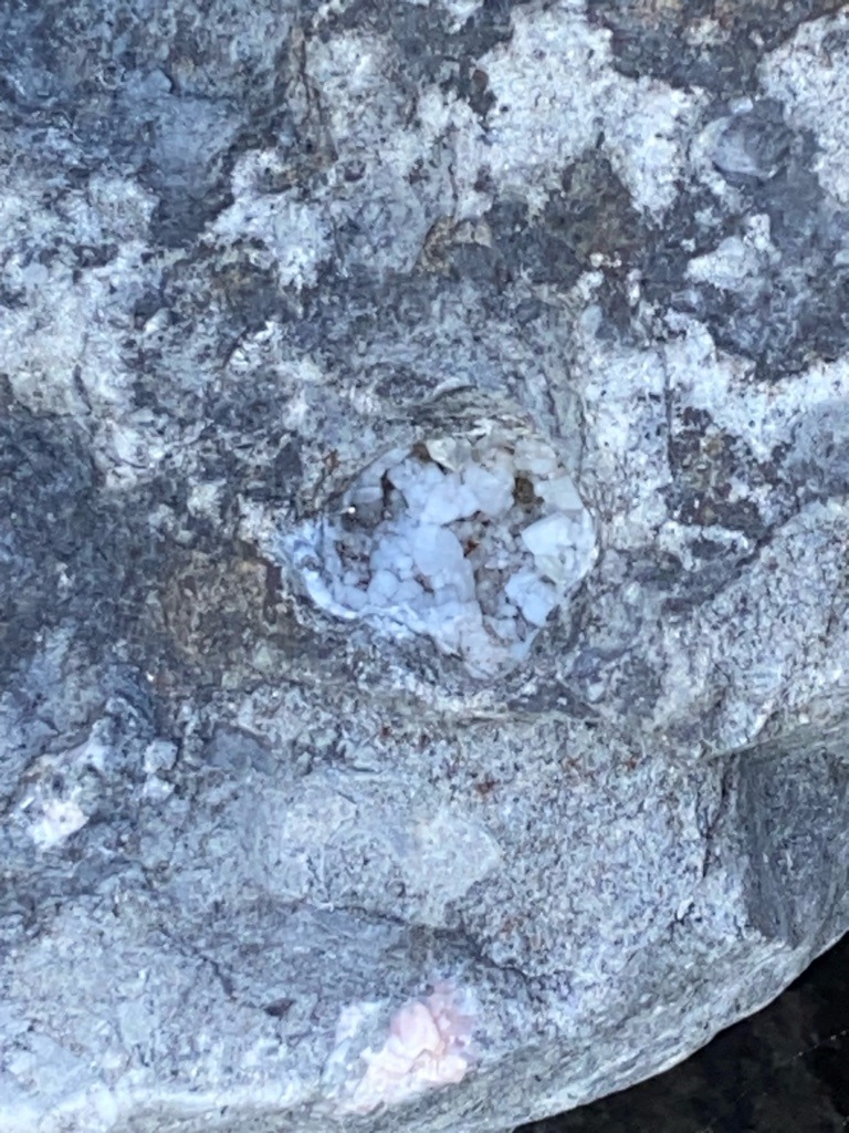 Not a diamond; the image shows a crystalline mineral cluster, likely quartz or calcite, embedded in a host rock matrix. - Irregular / Crystalline aggregate
