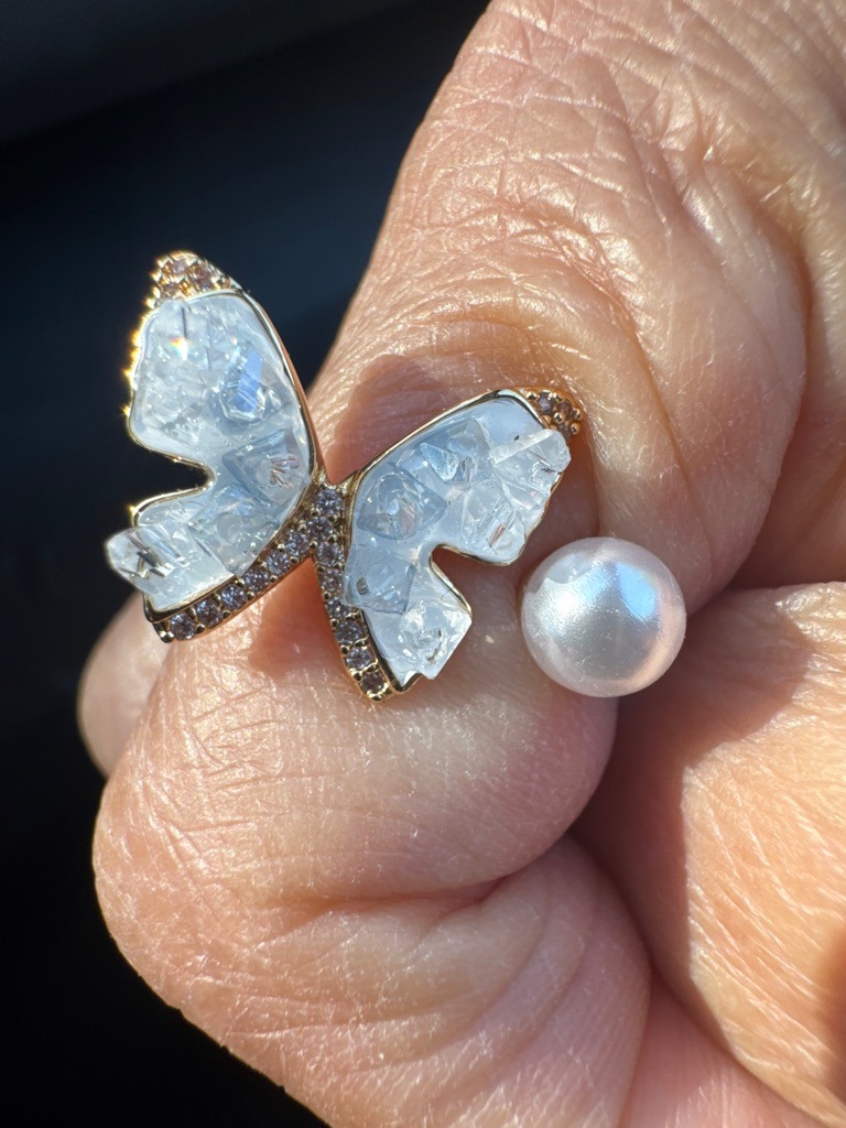 The center butterfly wings appear to be constructed using crushed ice crystal quartz or composite mosaic style assembled stones rather than a single unified diamond. The small accent stones along the body and edges may be cubic zirconia or melee diamonds. - Custom butterfly wing shaped mosaic/assembled arrangement
