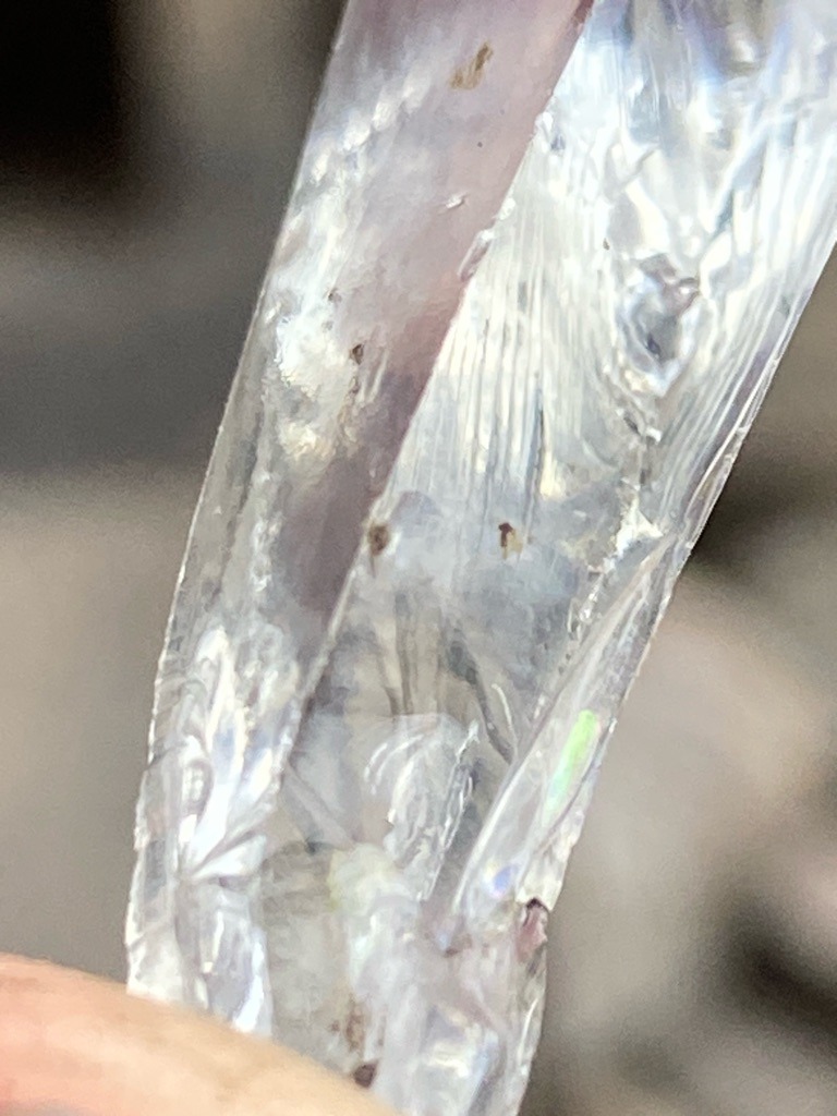 Not a diamond; appears to be plastic, resin, or synthetic crystal material with significant surface wear and inclusions. - Irregular, curved object; not applicable to standard diamond cuts.