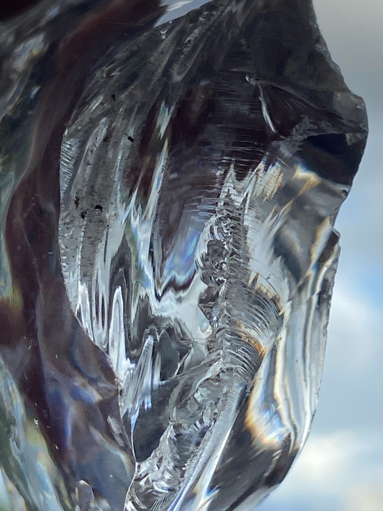 Not a diamond; appears to be raw glass, slag, or a synthetic vitreous material showing conchoidal fracture patterns. - Rough / Ungraded, irregular amorphous form