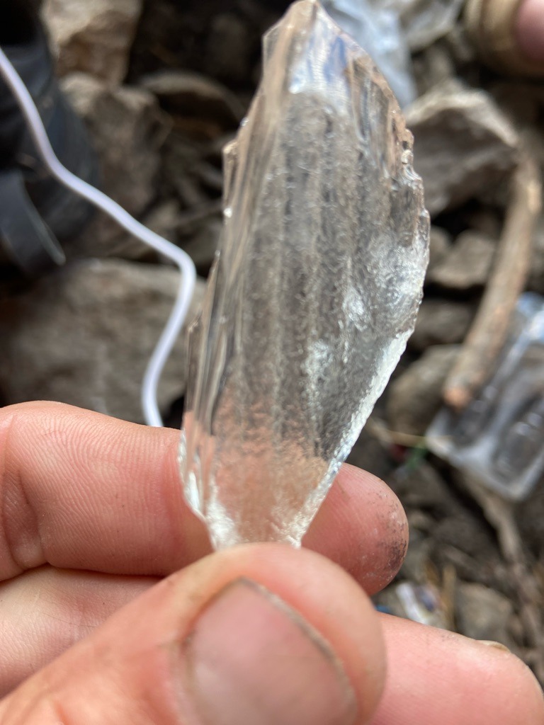 Not a diamond; appears to be raw quartz or glass/slag crystal - Rough uncut irregular shard
