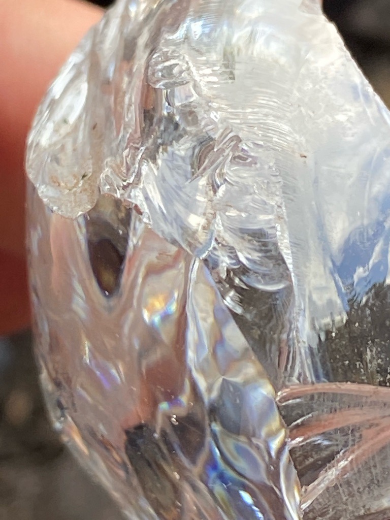 Not a diamond; appears to be quartz, glass, or an alternative mineral with conchoidal fracture and iridescent play of color. - Rough / Ungraded, organic or raw irregular crystalline mass.