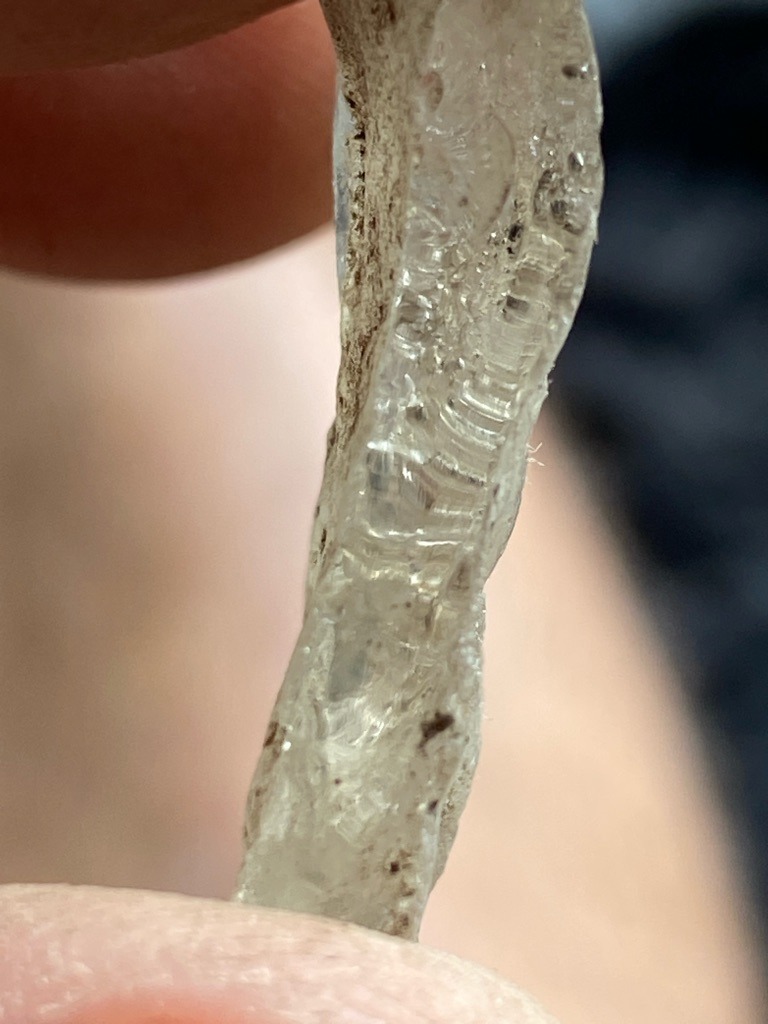 Not a diamond; likely a piece of textured glass, quartz, or resin based on the internal conchoidal fracture patterns and fibrous inclusions visible. - Irregular raw or melted fragment, non-standard shape