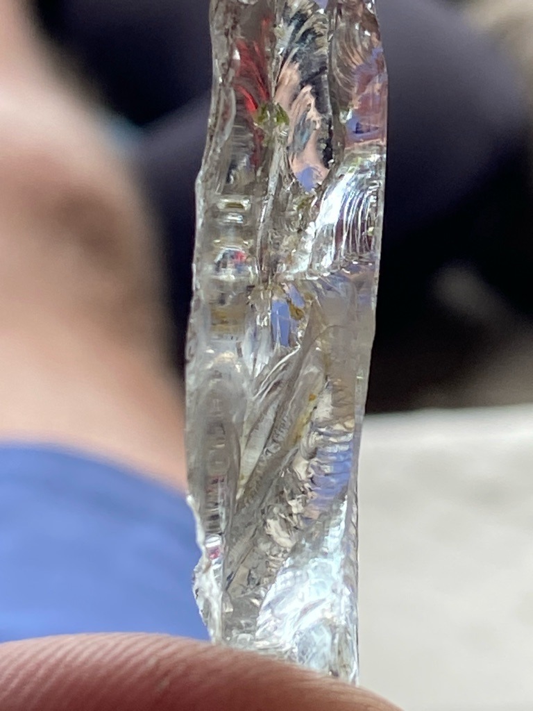 Not a diamond; this specimen appears to be optical glass, quartz, or another crystalline material exhibiting conchoidal fracture and surface striations inconsistent with natural diamond crystal habit. - Raw crystal fragment / Irregular rough slice