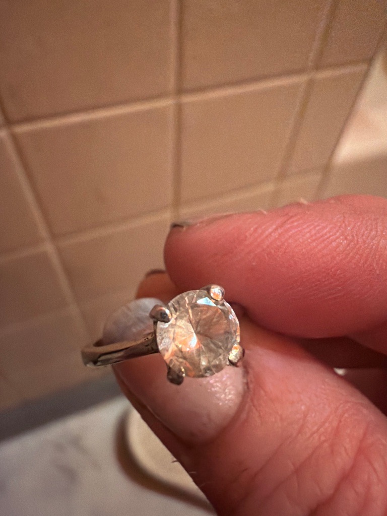 Natural Diamond (estimated based on visual appearance and traditional four-prong white gold/platinum mounting, though lab-grown cannot be ruled out without advanced testing) - Round Brilliant