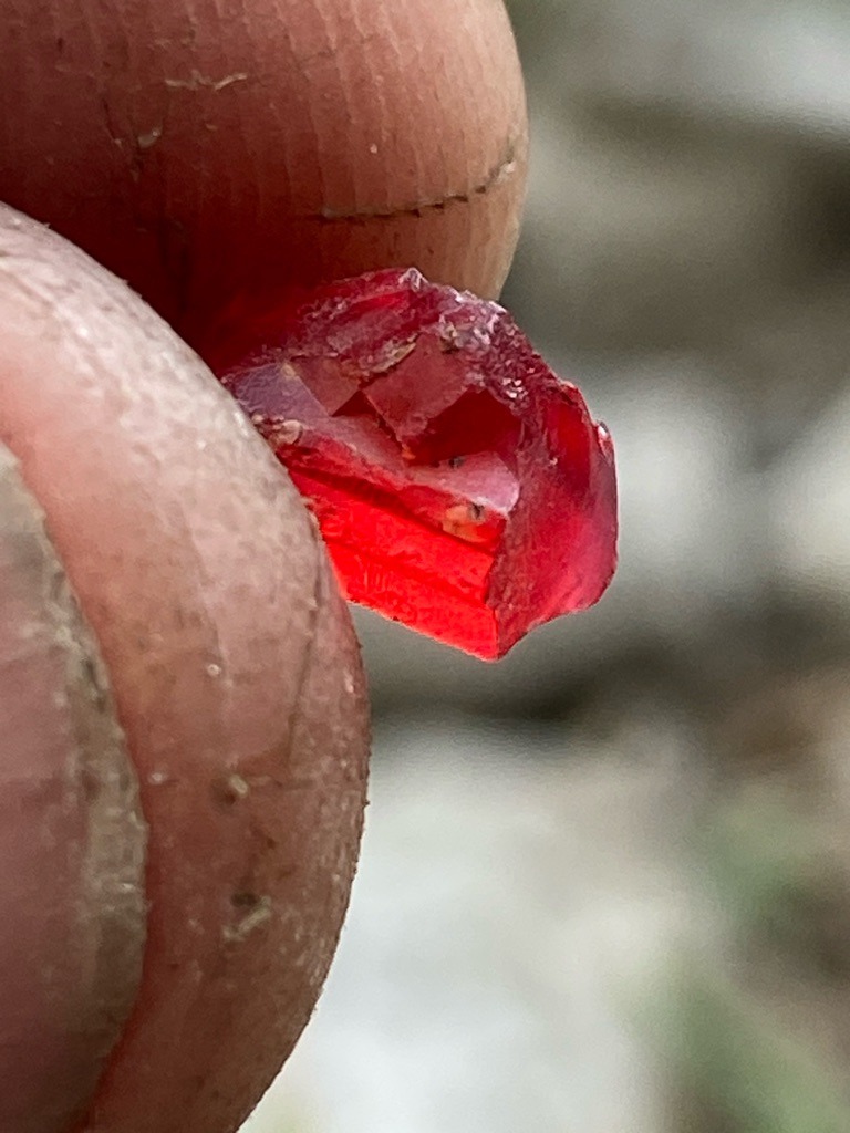 Not a diamond (appears to be a natural rough gemstone, likely red spinel, ruby, or tourmaline, as red natural diamonds are exceedingly rare and this specimen shows crystal habit typical of corundum or spinel) - Rough crystal / Uncut natural crystal habit