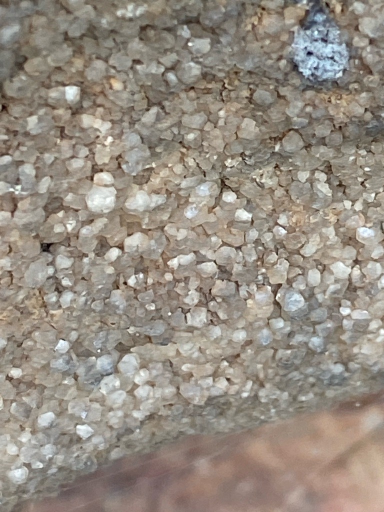 Not diamonds; these are mineral aggregate rock or sand grains, likely quartz or sandstone matrix. - Irregular micro-grains / granular aggregate