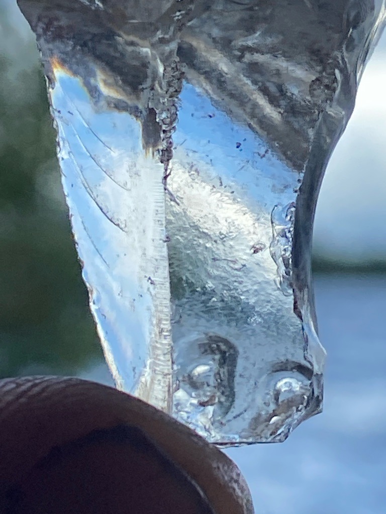 Not a diamond; likely manufactured glass, quartz fragment, or ice due to the presence of rounded air bubbles, conchoidal fractures, and non-crystalline surface texture. - Irregular raw fragment / unstructured shard