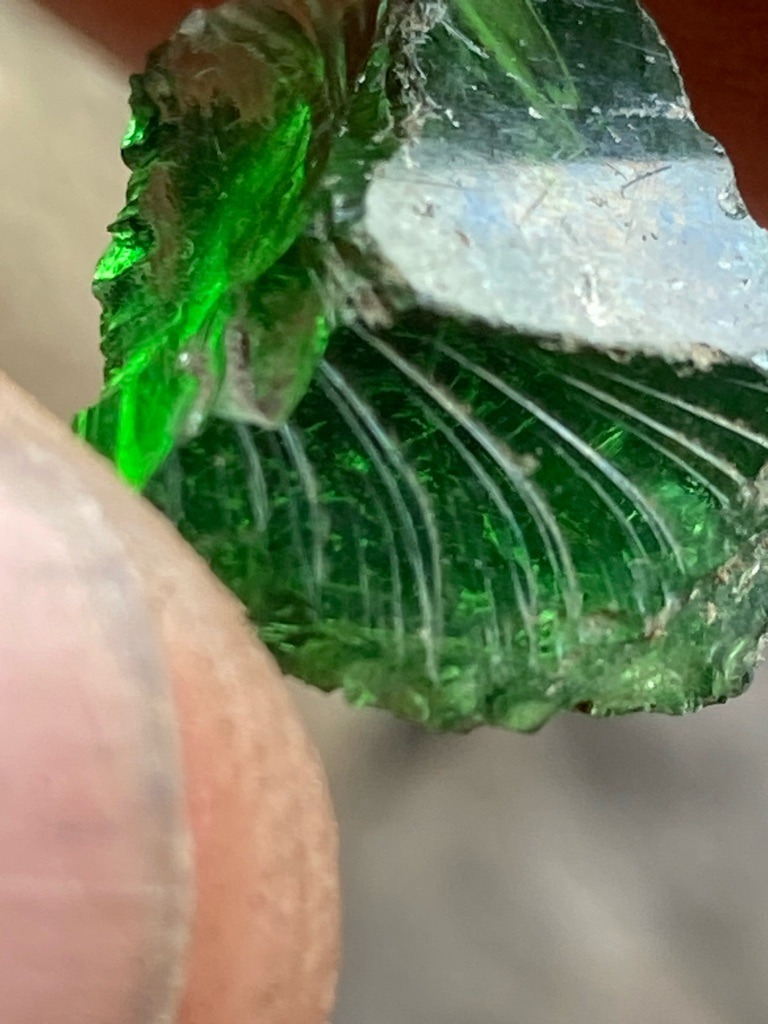 Not a diamond (Green Glass or Slag Glass exhibiting conchoidal fracture with distinct curved ripple marks known as hackly or conchoidal fracture lines typical of amorphous materials). - Raw, uncut, amorphous fragment with conchoidal fracture.
